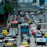 A bustling scene of cars and buses in a traffic jam on Bangkok's expressway.